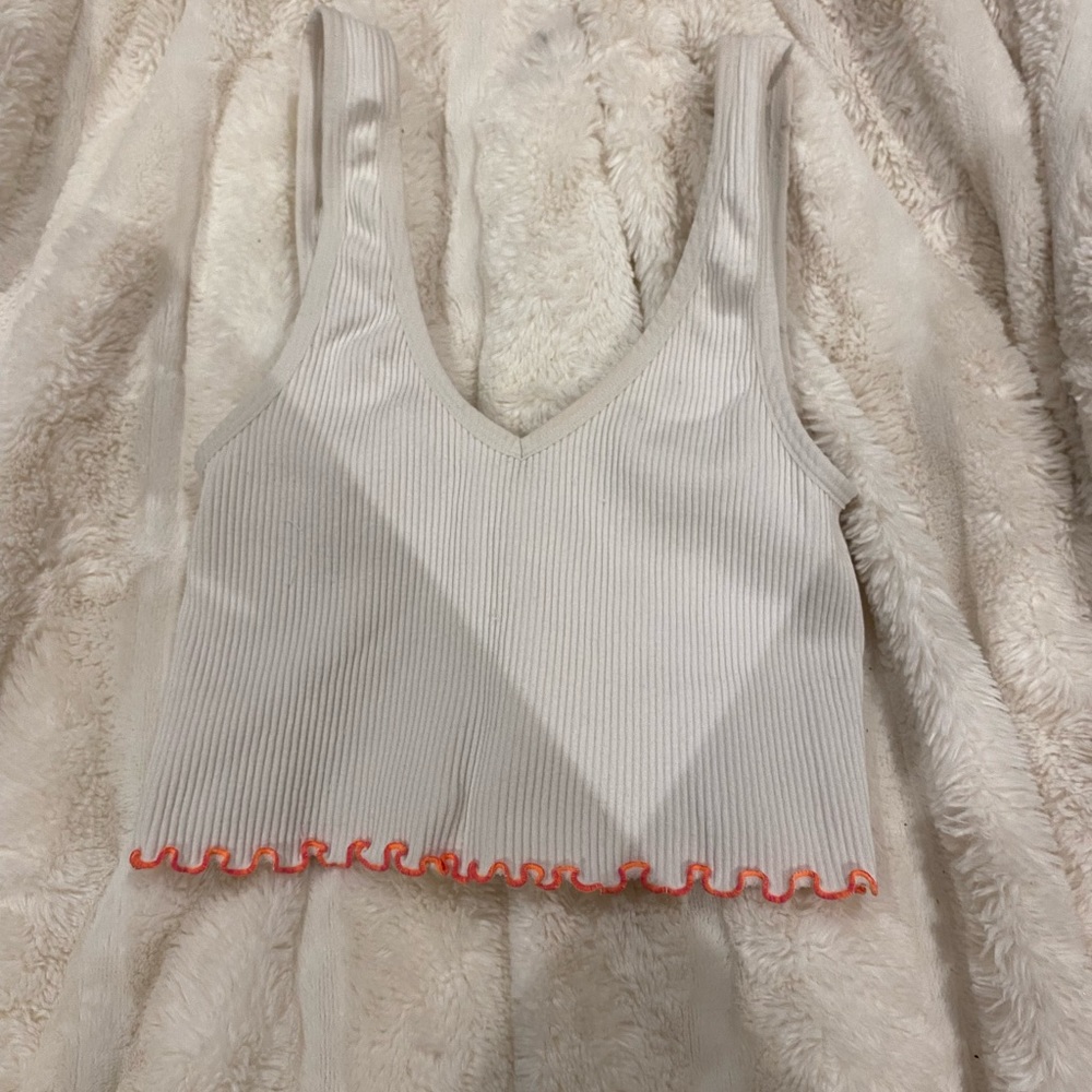 White tank top with orange ruffle on the bottom